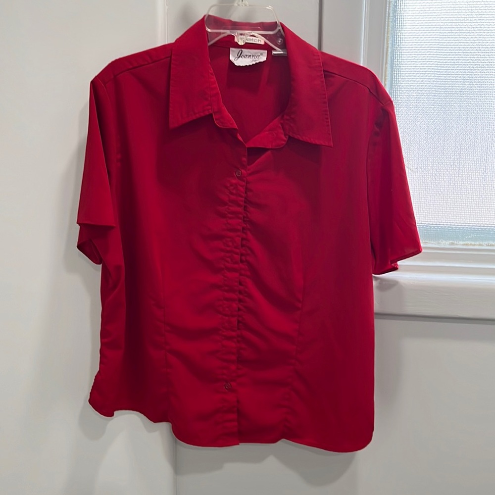 Red colored blouse with short sleeves and buttons in the front.